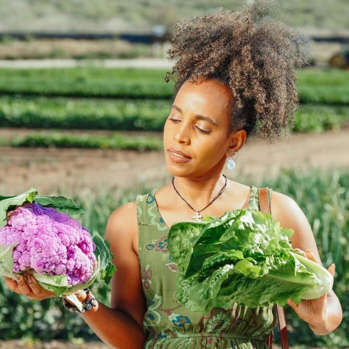 Woman in Green Dress Holding Cauliflower and Lettuce