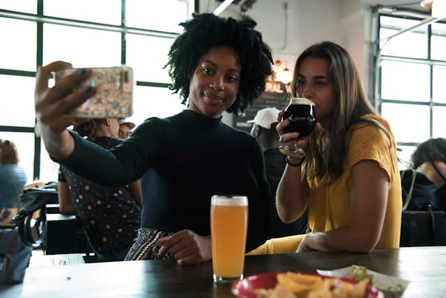 Two Women Taking a Picture at a Trendy Restaurant | Photo by Elevate