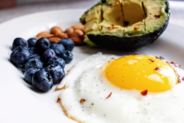 Eggs near Blue Berries and Avacado | Photo by Jenna Hamra